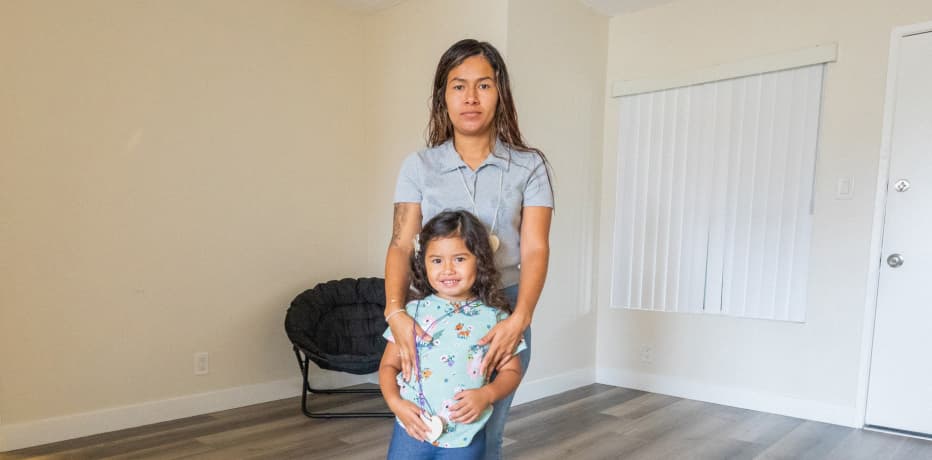 Mother and Daughter stand in an empty apartment