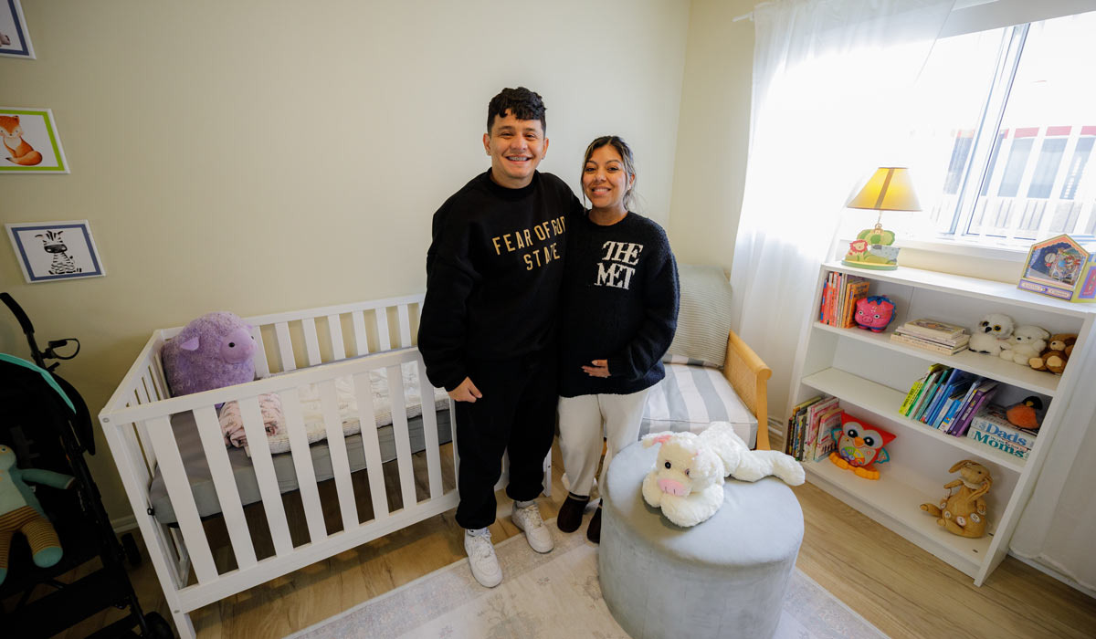 Two people stand in their new remodeled bedroom