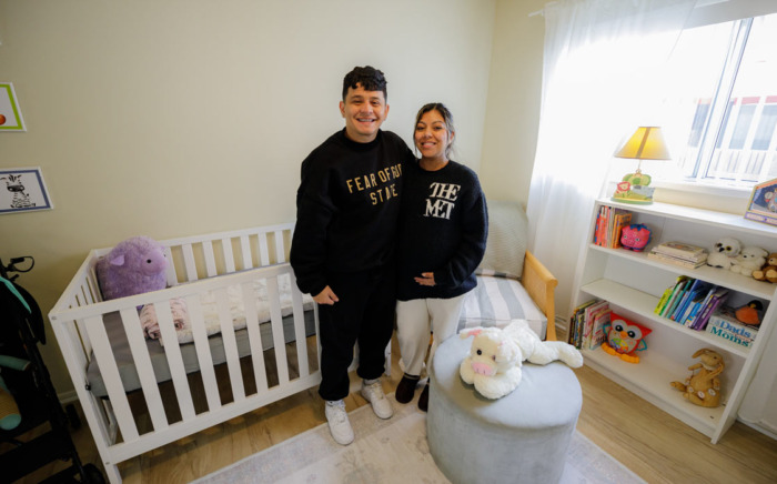 Two people stand in their new remodeled bedroom