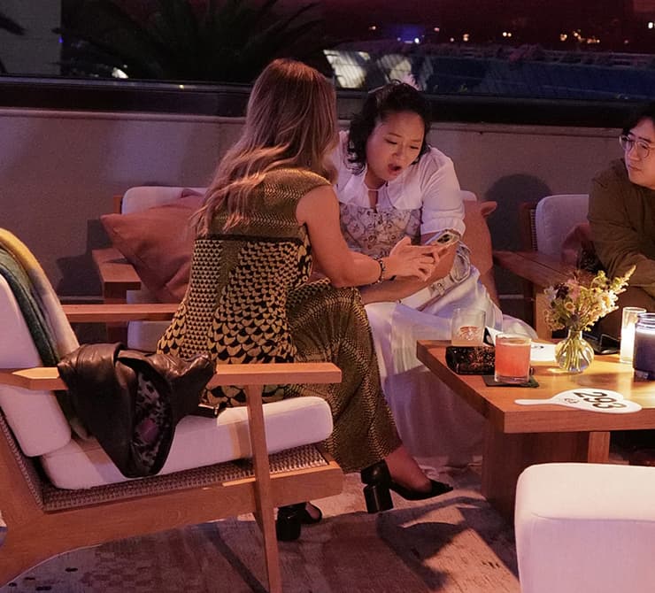 Two people sit together and look at a phone