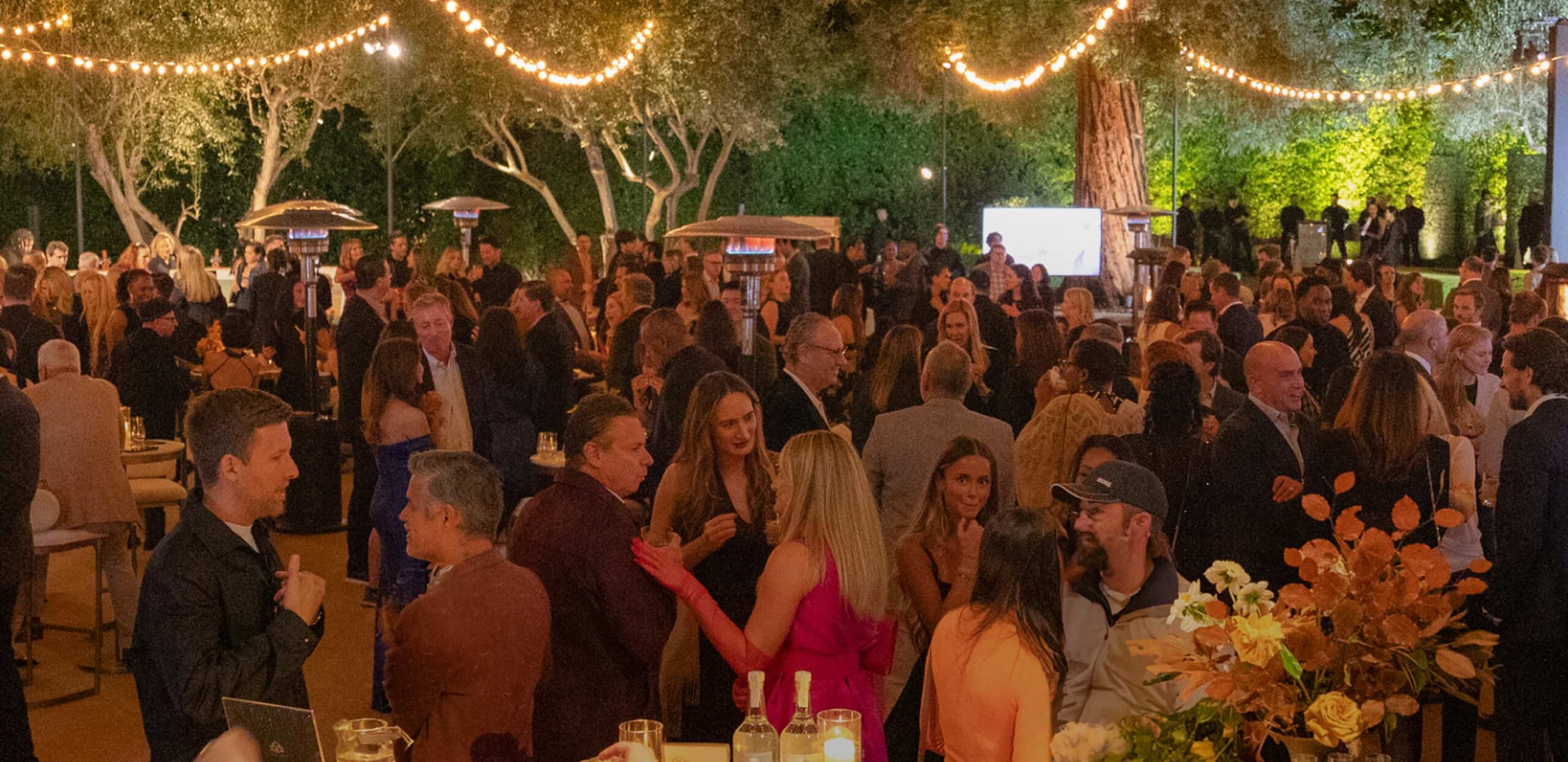 Guests gathered at an evening A Sense of Home gala under string lights