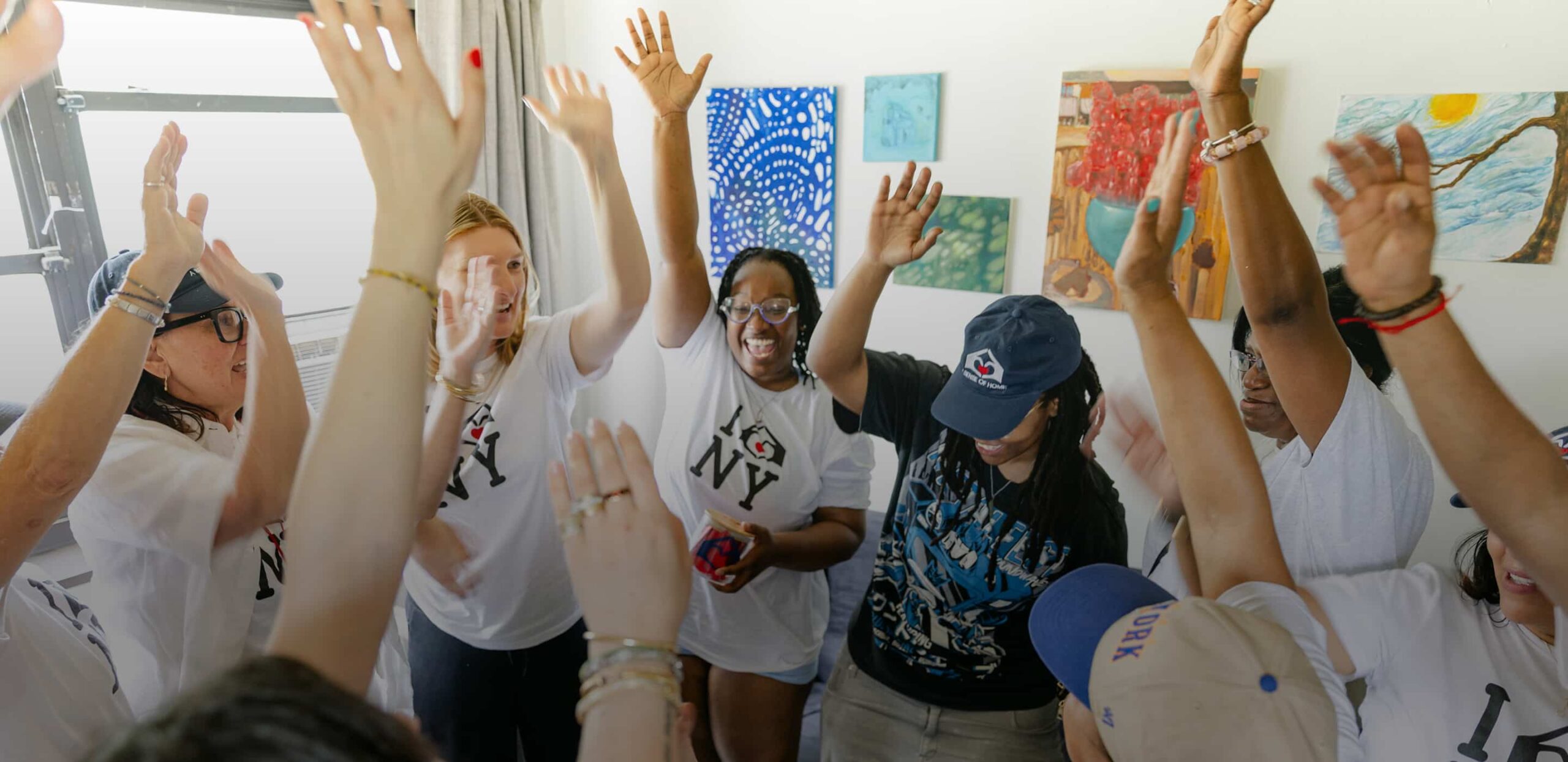 A Sense of Home youth and volunteers celebrating with their arms raised