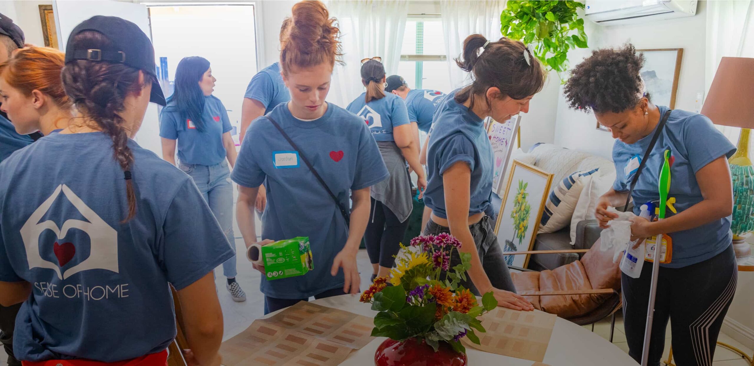 A Sense of Home volunteers in matching shirts preparing a new home together