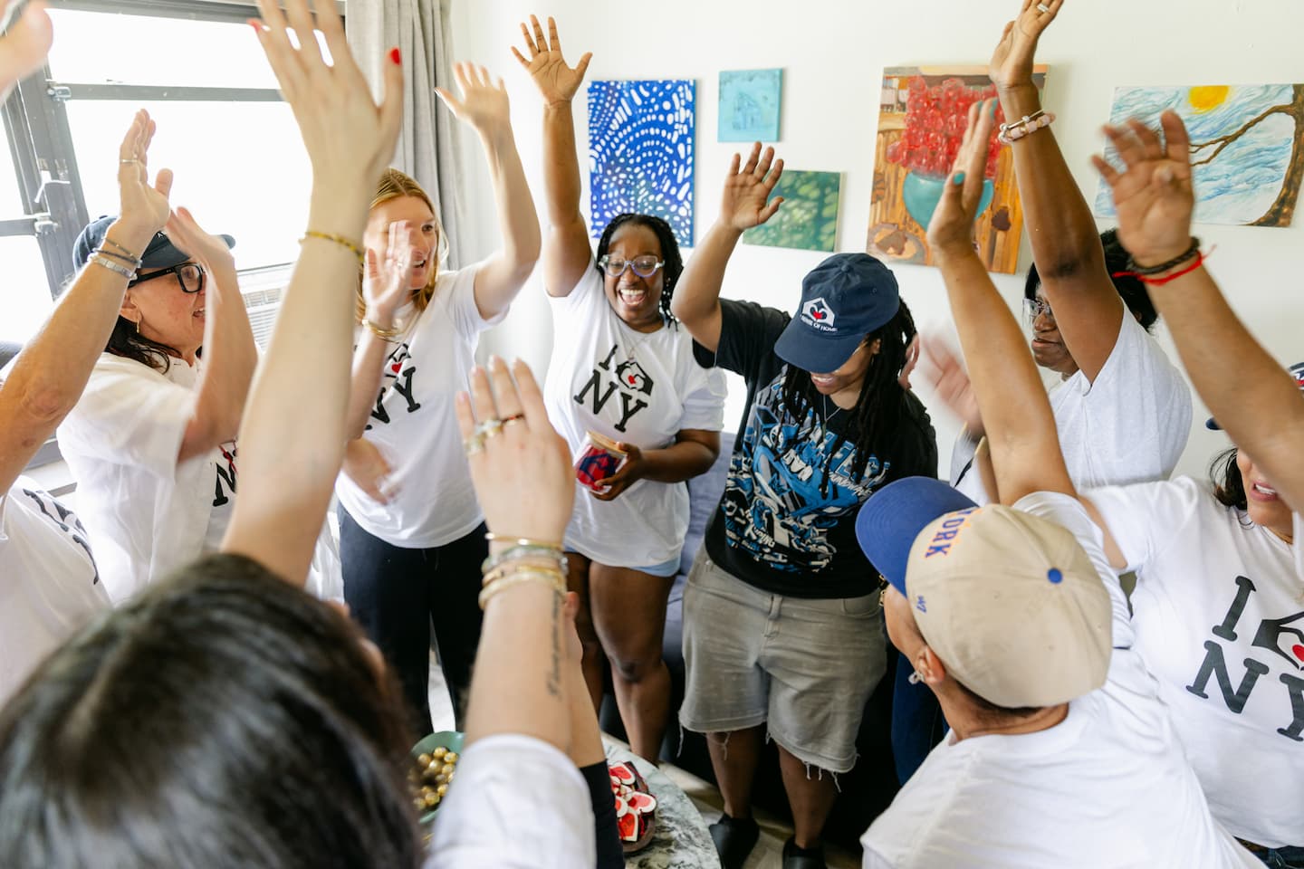 A Sense of Home youth and volunteers celebrating with their arms raised